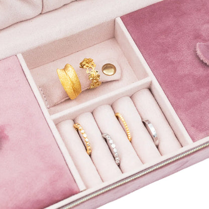 Image de la boîte à bijoux rose rectangulaire avec un gros plan sur les bagues